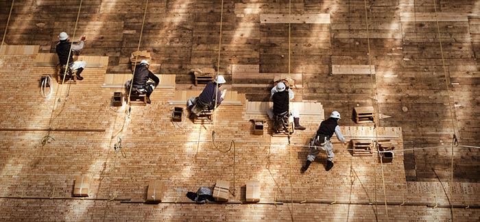 Image of team of builders nailing cedar shakes for Quotacy blog The Parties Involved in Buying Life Insurance.