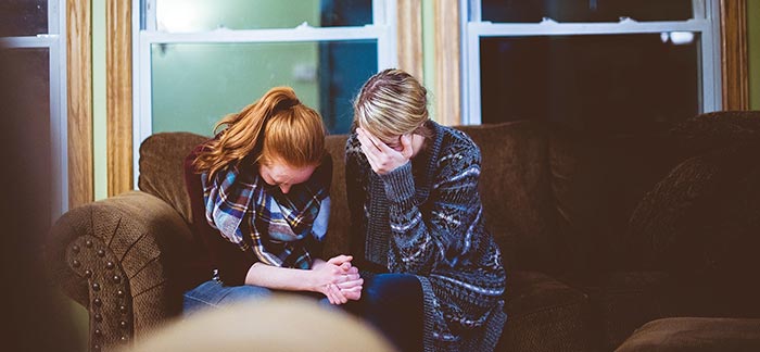 Image of a woman consoling her grieving friend for Quotacy blog Tips for Helping Console a Grieving Friend.