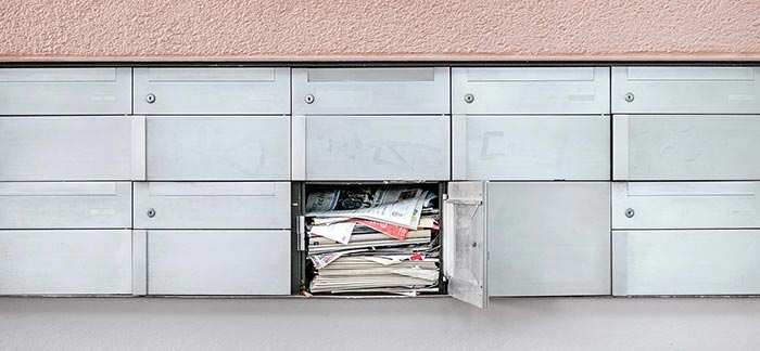 full mailbox with door open in an apartment complex