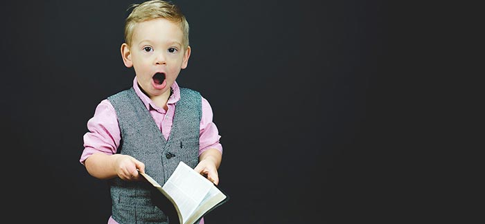 surprised toddler holding an open book