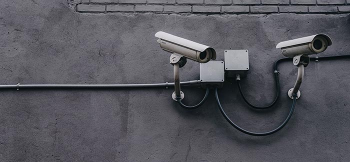 Image of security cameras on a wall for Quotacy blog Keeping Your Personal and Financial Information Secure On-and-Offline.