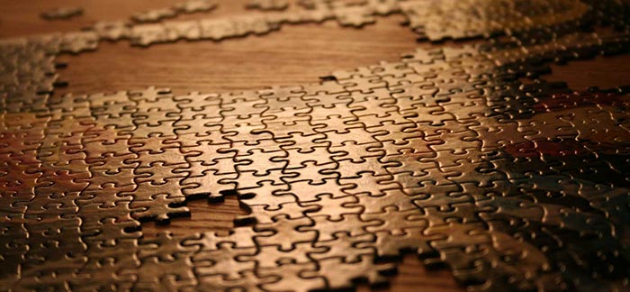 Image of unfinished puzzle on a table for Quotacy blog 25 Year Term: The Perfect Fit Policy.