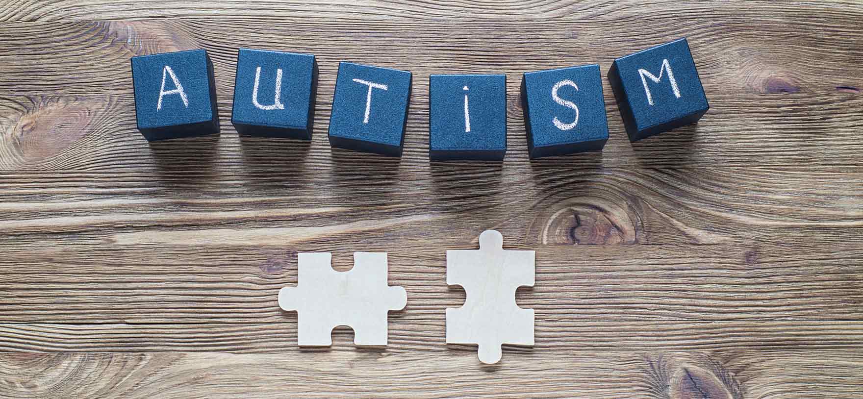 Image of blocks spelling out the word autism and puzzle pieces for Quotacy blog Life Insurance and Autism: Buyer's Guide.