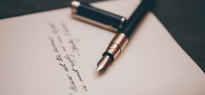 Image of fountain pen on paper with writing on it for Quotacy blog The Importance of Writing a Will.