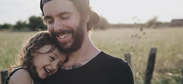 Image of dad and daughter hugging outside in a field for Quotacy blog Top Two Reasons People Don't Buy Life Insurance.