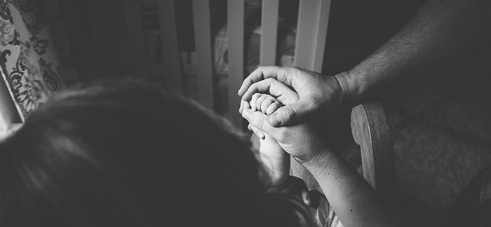 Image of a man, woman, and child holding hands