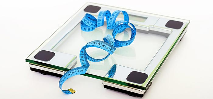 Image of bathroom scale with tape measure for Quotacy blog Height and Weight & Your Life Insurance Application.
