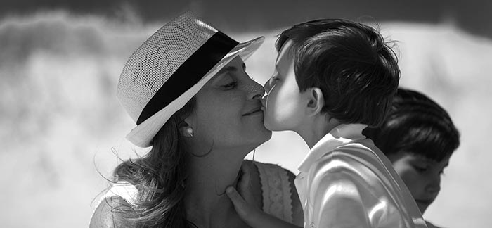 Image of a mother giving her child a kiss for the Quotacy blog, The Importance of Life Insurance for Single Parents.