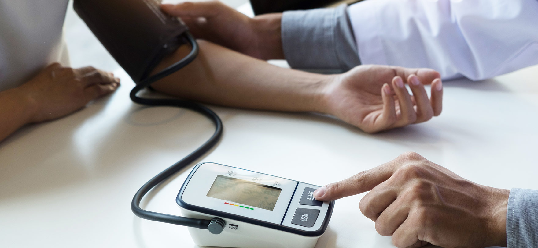 Image of doctor taking patient's blood pressure for Quotacy blog Life Insurance and Coronary Artery Disease: Buyer's Guide