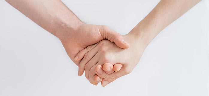Image of couple holding hands for Quotacy blog How to Find Financial Peace with Your Spouse.
