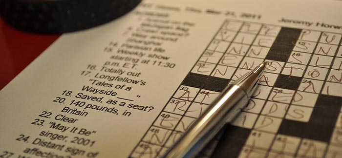 Image of pen on a newspaper crossword puzzle with letters filled in for Quotacy newsletter How We Make and Break Bad Habits.