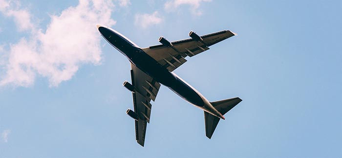 Image of plane flying in the sky on a sunny day