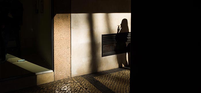 Image of shadow of person smoking a cigarette for Quotacy blog Life Insurance Risk Classes for Cigarette Smokers.