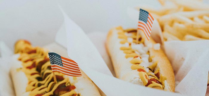two hot dogs with american flags on toothpicks