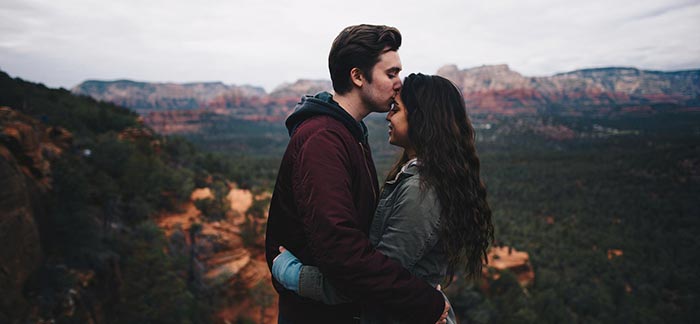 Image of man kissing woman overlooking a southwest canyon