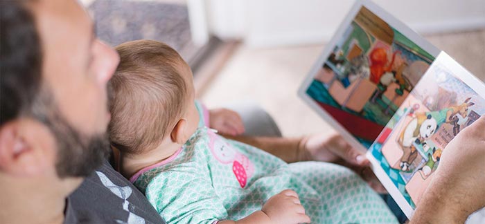 Image of father reading a story to baby girl