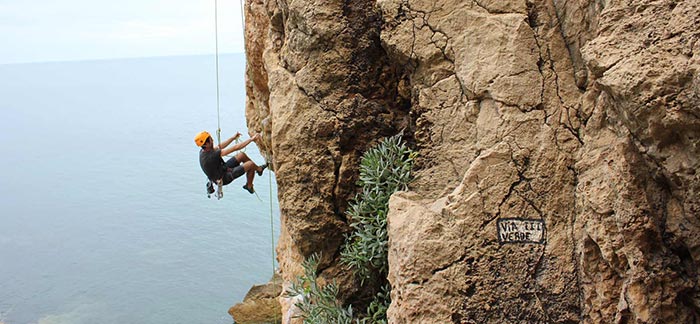 Image of man repelling dow a cliff over the ocean for Quotacy blog The Five Most Common Risky Hobbies That Underwriters See.