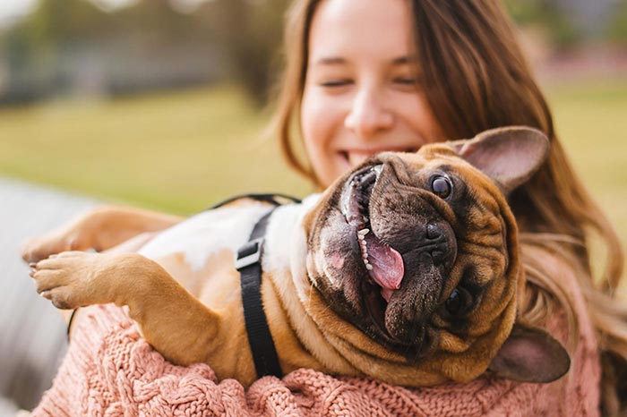Image of woman hugging a dog for Quotacy blog: Trying to Compare Life Insurance Quotes Yourself? Here’s 8 Ways to Better Spend Your Time.