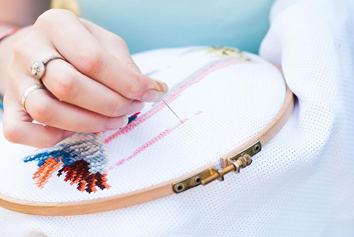 Close up image of hands stitching a design for Quotacy blog: Trying to Compare Life Insurance Quotes Yourself? Here’s 8 Ways to Better Spend Your Time.