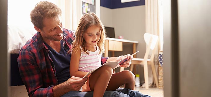 Image of dad reading a book to his daughter for Quotacy blog: Which Is Better for Single Parents: Term or Whole Life Insurance?