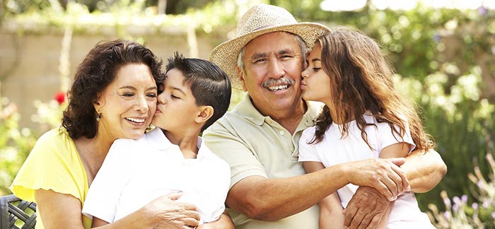 Image of grandma and grandpa hugging their grandchildren