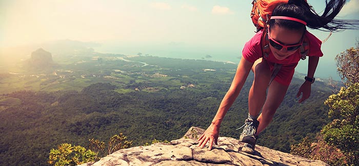 Woman rock climbing on vacation for Quotacy blog Term Life Insurance for Adventure Travelers