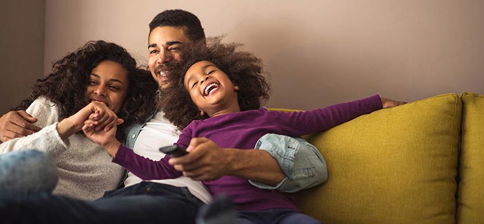 Family cuddling on the couch for Quotacy blog What Do I Need to Know About Life Insurance?