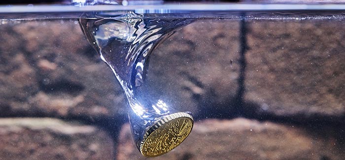 Image of a coin being thrown into a well