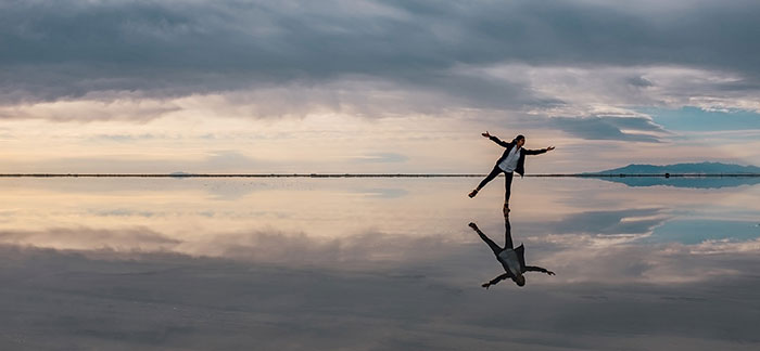 Image of woman on frozen lake with image reflected on the lake for Quotacy blog What Happens If I Don’t Die While My Policy Is Inforce?