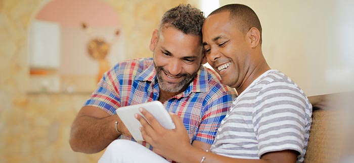 Image of two men looking at a tablet for the Quotacy blog: The Best Life Insurance & Financial Planning Tips for Same-Sex Couples.
