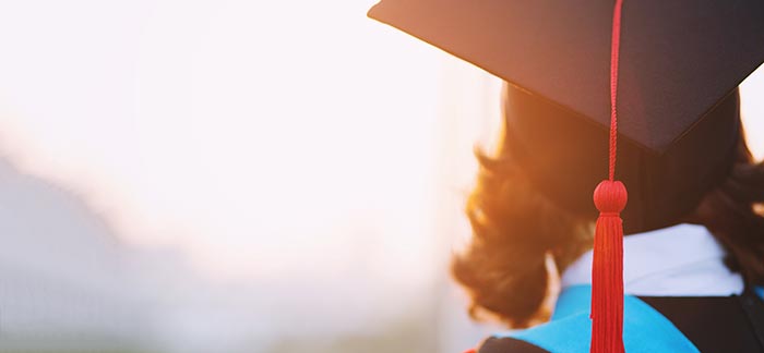 Image of a person wearing a graduation cap and gown.