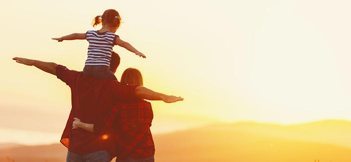 mom and dad with daughter on dad's shoulders for Quotacy blog Why Are My Life Insurance Rates Different Than My Spouse’s?