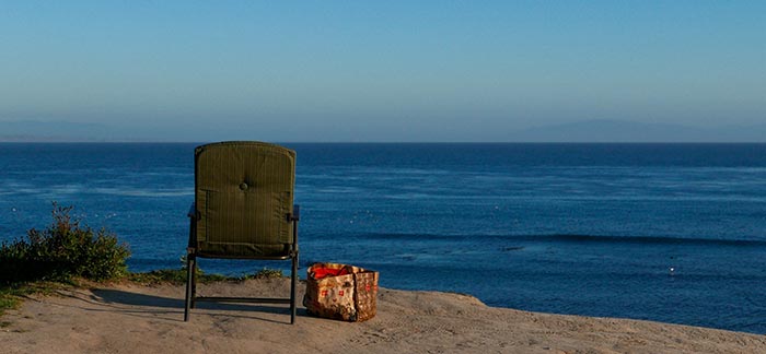 solitary chair facing the ocean for Quotacy blog Life Insurance Claim for a Missing Person