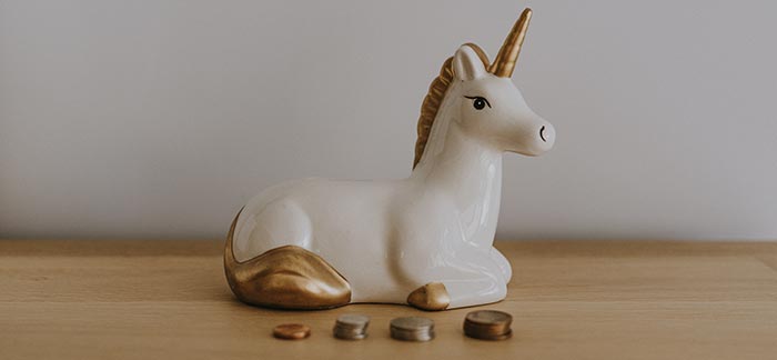 Unicorn bank with coins for Quotacy blog How to Save Money Fast: Be a Better Spender in 2020