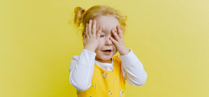 young child hiding her eyes for Quotacy blog Are There Hidden Fees in Life Insurance?
