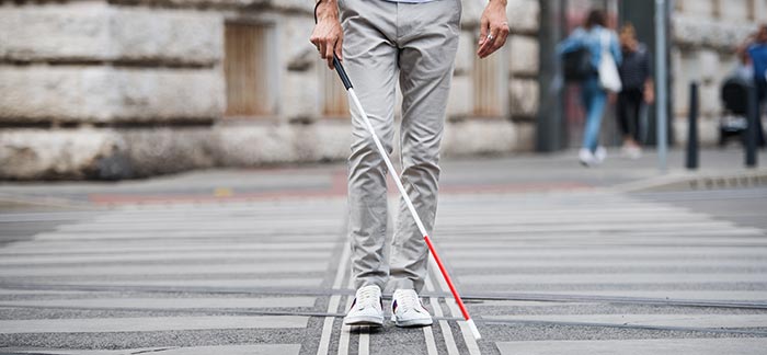 person walking with blind cane for Quotacy blog Buying Life Insurance for Blind and Hearing Impaired