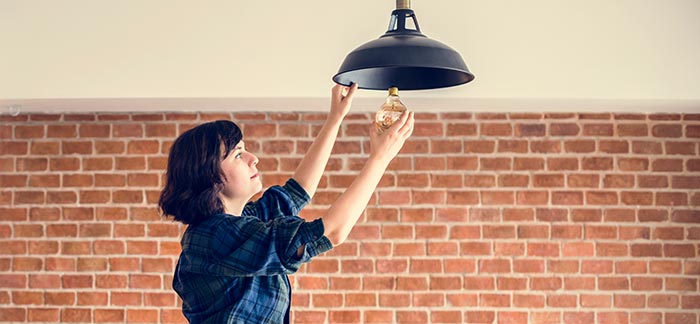 woman replacing a light bulb Replacing Life Insurance Policies