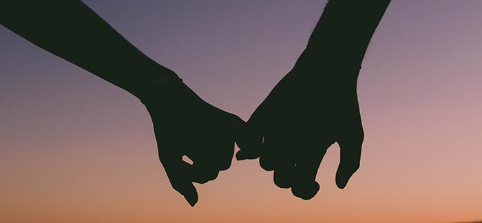 couple holding hands against sunset for Quotacy blog How Much Is Life Insurance in My 40s?