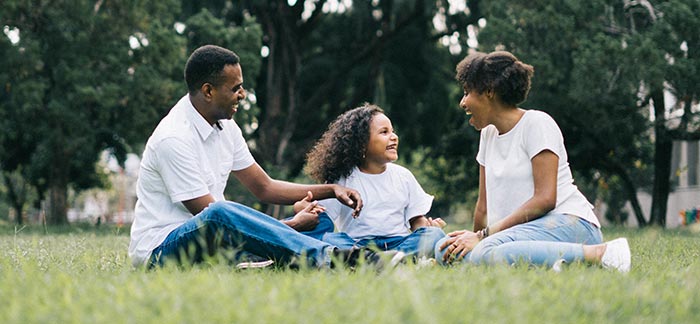 young family sitting in park for Quotacy blog where should I buy life insurance