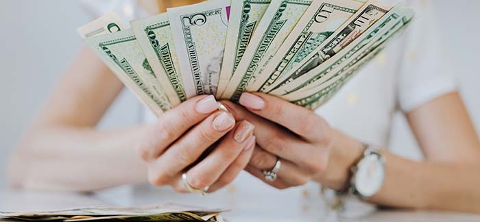 woman holding cash for Quotacy blog difference between types of savings accounts