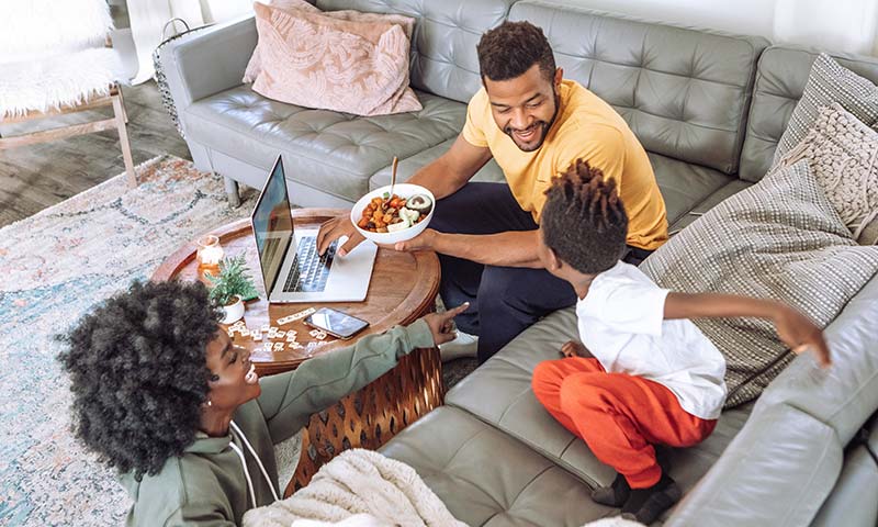 Mom, dad and son playin together in their living room.