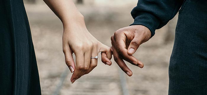 engaged couple fingers intertwined for Quotacy blog about guaranteed universal life insurance