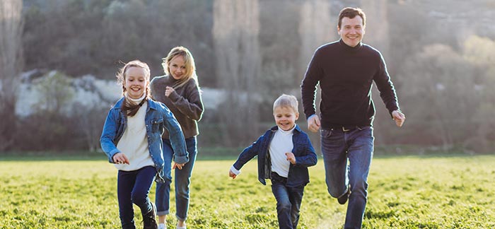 mom dad and children running through yard