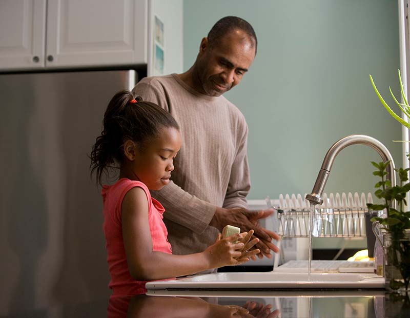 Dad and daughter washing dishes.
