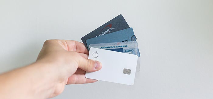 person holding credit cards for Quotacy blog Tips, Ideas and Strategies for Paying Down Debt