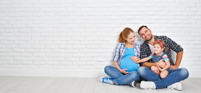 young father and pregnant mother sitting with toddler for Quotacy blog affordable family life insurance