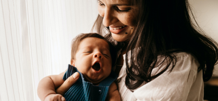 mom holding yawning baby for Quotacy blog best life insurance for women