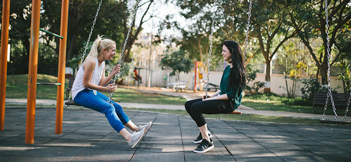 two women speaking at a park