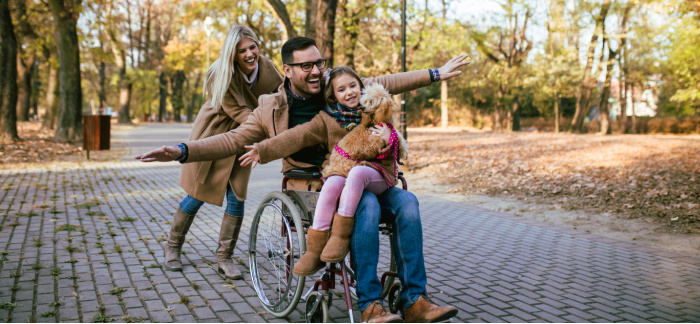 man in wheelchair with wife and daughter for Quotacy blog disability income insurance 101