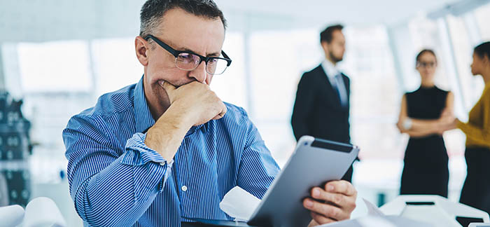 older man looking at digital insurance policy for Quotacy blog about replacing life insurance